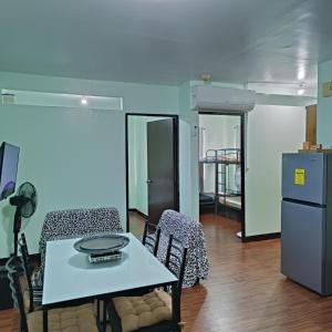 a room with a table and chairs and a refrigerator at Raljer Homes in Manila