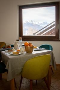 een tafel met een bord eten en een raam bij Green Mountain Lodge in Sauze dʼOulx