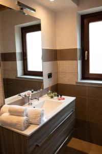 een badkamer met een wastafel en een grote spiegel bij Green Mountain Lodge in Sauze dʼOulx