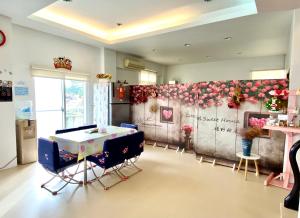 una stanza con tavolo e sedie e fiori sul muro di Green Field Sweet House a Jiaoxi