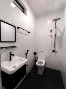 a white bathroom with a sink and a toilet at Villa Bonda Langkawi in Pantai Cenang
