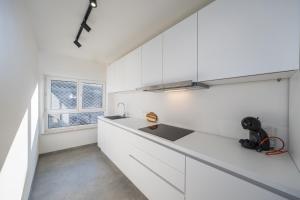 una cucina bianca con lavandino e finestra di The Bright Cosy Corner a Ostenda