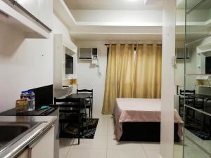 een kleine kamer met een bed en een keuken bij Grand Riviera suite Condotel in Manilla