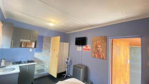 a room with a bathroom with a sink and a mirror at Destiny Guesthouse in Germiston