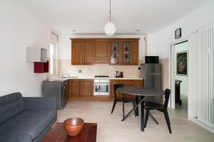 uma cozinha com um sofá e uma mesa num quarto em Casa Bruna em Aosta