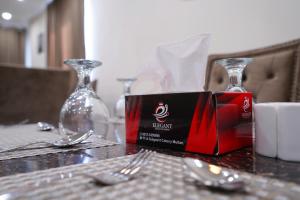 un tavolo con una scatola di vino su un tavolo con forchette di Elegant Executive Suite a Multan