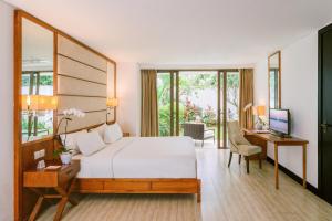 a bedroom with a bed and a desk with a computer at Lv8 Resort Hotel in Canggu