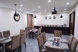 un restaurante con mesas y sillas en una habitación en Elegant Executive Suite en Multán