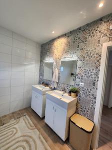 a bathroom with two sinks and two mirrors at NEW Luxury villa near Belgrade for 20 guests sleeps 8 in Vlaška