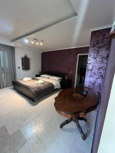 Villa Cecilia في بوتسولي: غرفة نوم بسرير وطاولة في غرفة