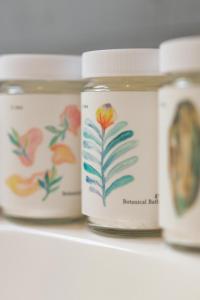 a row of jars with flowers on them on a shelf at e-ma ISHIGAKIJIMA TABISHIKA in Ishigaki Island