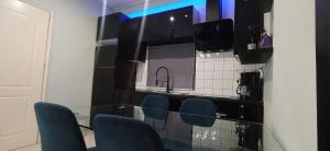 a kitchen with blue chairs and a counter with a sink at Maka's Design Suite-Trikala in Tríkala