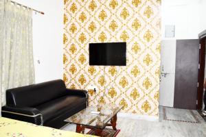 a living room with a couch and a tv on a wall at Ramaya’s Home Stay in Varanasi