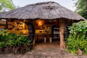 a small hut with a table and a straw roof at Victoria Falls Backpackers Lodge- Camp Sites in Victoria Falls