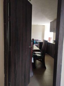 una puerta abierta a una habitación con mesa y sillas en departamento individual equipado, en Ibarra