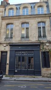 un edificio con una fachada negra en una calle de la ciudad en Studio au cœur des Chartrons, en Burdeos