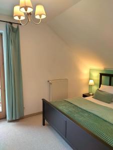 1 dormitorio con 1 cama con colcha verde en Traumhafte Ferienwohnung auf 100 Quadratmetern für 6 Pers nähe München, ICM, Therme, MUC en Forstinning