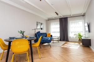 a dining room with a table and yellow chairs at Vaivute Apartments No2 in Darbėnai