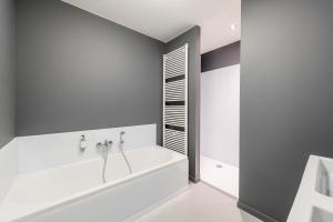 Baño blanco con bañera y lavamanos en Smartflats Design - Postiers, en Bruselas