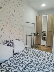 sypialnia z łóżkiem z czarno-białą kołdrą w obiekcie Joker w mieście Požarevac