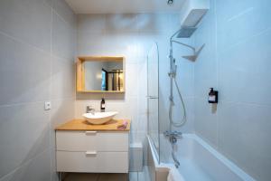 a white bathroom with a sink and a shower at Suite du Vieux Lyon Cosy & calme - le Quarantaine in Lyon