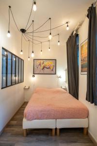 a bedroom with a king sized bed and lights at Suite du Vieux Lyon Cosy & calme - le Quarantaine in Lyon