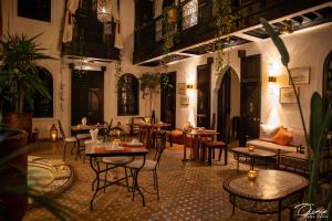 una stanza con tavoli e sedie in un edificio di Riad Zoraida a Marrakech