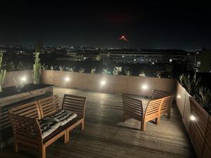 dwa krzesła i stół na balkonie w nocy w obiekcie Terrazza Sangiuliano w Katanii
