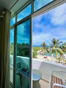 a room with a view of the ocean from a balcony at Leisure Boutique Maafushi 维尼家 in Maafushi