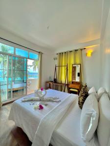 Leisure Boutique Maafushi 维尼家 في مافوشي: غرفة نوم بسرير ابيض مطلة على المحيط
