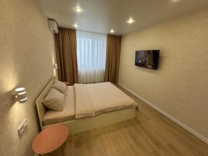 ヴィーンヌィツャにあるЛюкс Апартаменты Cream Pearl на подольеのベッドと窓が備わる小さな客室です。