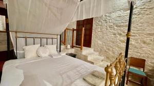 een slaapkamer met een wit bed en een baldakijn bij Juliet Suite by TrulyCyprus in Doros