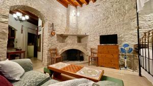 ein Wohnzimmer mit einer Steinmauer und einem Kamin in der Unterkunft Juliet Suite by TrulyCyprus in Doros