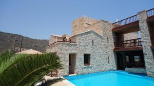 a building with a swimming pool in front of it at Simosmare Resort in Elafonisos