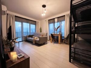 een woonkamer met een bank, een bed en een tafel bij AmurResidence ap3 2 rooms 5min-Airport/Center free parking in Iaşi