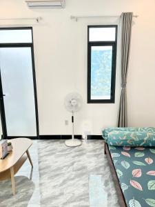 a living room with a couch and a fan at Koi Guest House - Phan Thiết in Ấp Thiện Phước