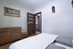 a bedroom with a bed and a wooden dresser at Apartament u Jacentego in Szklarska Poręba