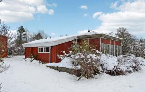 un edificio rosso con neve per terra di 3 Bedroom Nice Home In Bog By a Bogø By