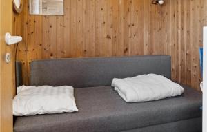 2 poduszki na łóżku w pokoju z drewnianymi ścianami w obiekcie 3 Bedroom Nice Home In Bog By w mieście Bogø By