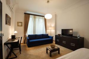 een woonkamer met een blauwe bank en een televisie bij Belgrade Center Apartment Lux V in Belgrado