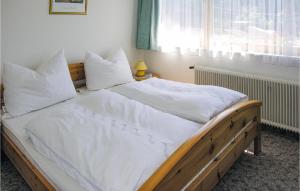 a bedroom with a large bed with white sheets and pillows at Stunning Apartment In Wagrain With Kitchen in Wagrain