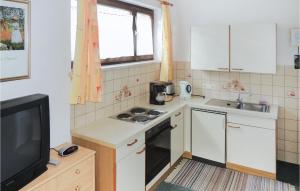 a small kitchen with a stove and a tv at Stunning Apartment In Wagrain With Kitchen in Wagrain
