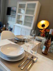 einen Tisch mit Tellern und Gläsern sowie eine Flasche Wein in der Unterkunft Moderner Altbaucharme in zentraler Lage in Kiel