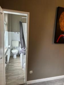 ein Bad mit WC und eine Tür zu einem Zimmer in der Unterkunft Moderner Altbaucharme in zentraler Lage in Kiel
