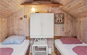two beds in a small room with wooden walls at Nice Home In Brovst With Jacuzzi in Brovst