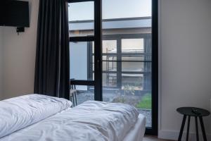 a bedroom with two beds and a large window at MarinaPark Residentie Nieuw Loosdrecht in Loosdrecht