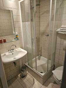 La salle de bains est pourvue d'une douche et d'un lavabo. dans l'établissement hotel le bonheur, à Eijsden