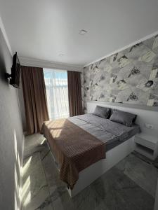 sypialnia z dużym łóżkiem i kamienną ścianą w obiekcie ApartHotel City Centrum w Kiszyniowie