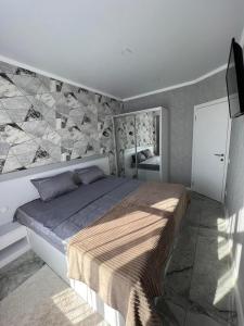 a bedroom with a large bed with a stone wall at ApartHotel City Centrum in Chişinău