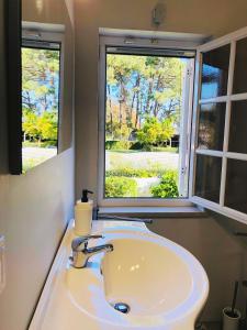 a bathroom with a sink and two windows at AYAMI Villa in Setúbal